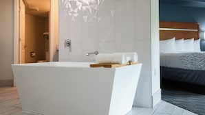 A modern bathroom with a freestanding bathtub, a shower, and a visible toilet.