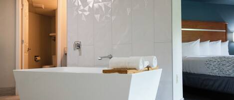 A modern bathroom with a freestanding bathtub, a shower, and a visible toilet.