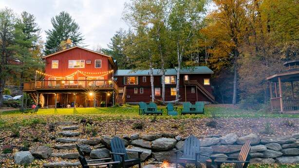 A cabin with a deck, outdoor seating, and a fire pit. - Timberholm Inn (Stowe)