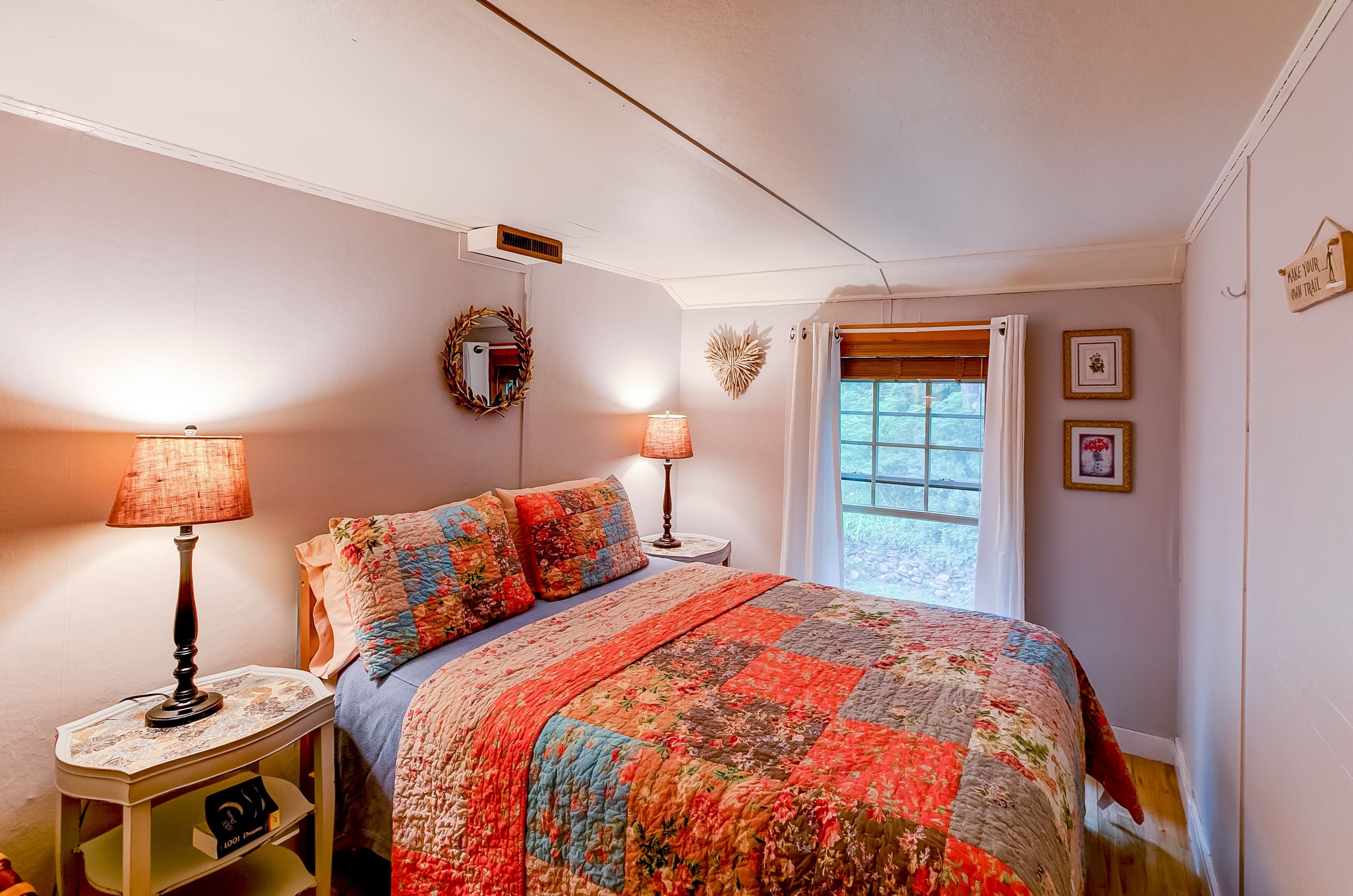 Une chambre à coucher avec un lit, deux lampes de chevet, une fenêtre avec des rideaux et des éléments décoratifs sur les murs.