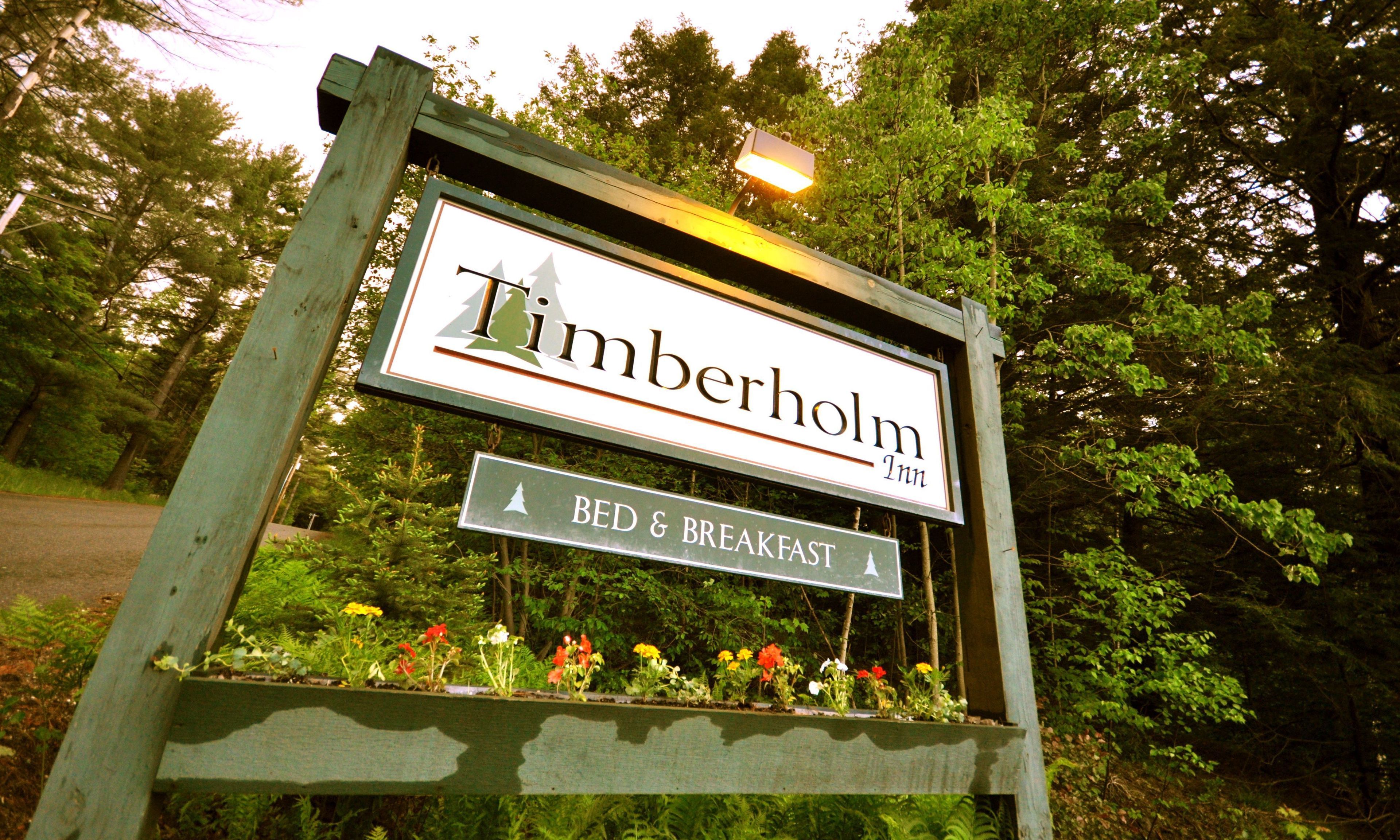 Een bordje voor Timberholm Inn met een bed en ontbijt aanduiding.