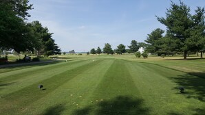 A well-maintained golf course with a clear path, trees, and a distant building. - SureStay Hotel by Best Western Thomson (Thomson)