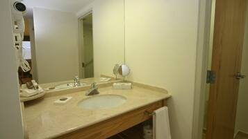 A bathroom with a sink, mirror, and towel rack.