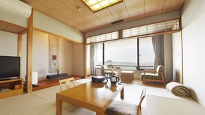 Un salon de style japonais traditionnel, avec un sol recouvert de tatamis, une basse table en bois et un téléviseur.