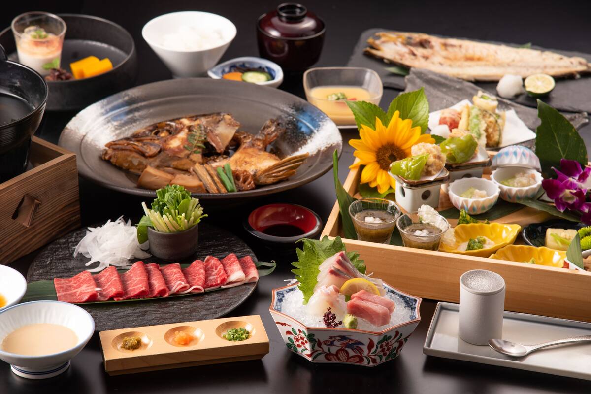 A variety of Japanese dishes including sashimi, tempura, and a bowl of soup.