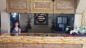 A reception area with a woven counter, framed artwork, and a sign for EZ Maps. - Treasure Island Resort (Olongapo)