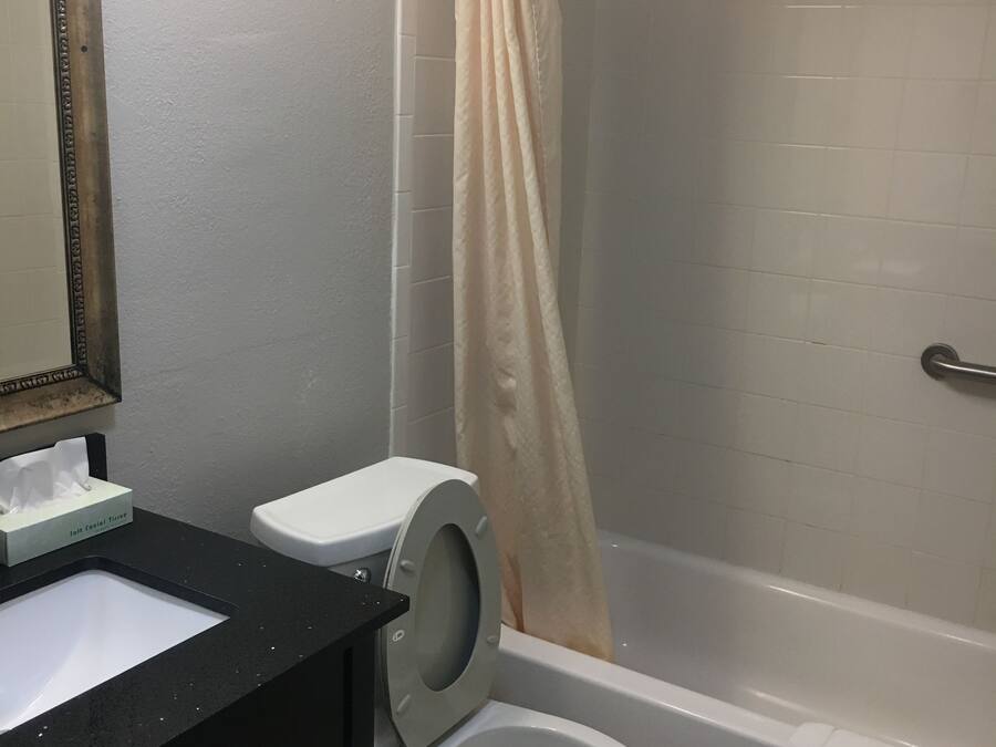 A bathroom with a toilet, sink, and shower area.