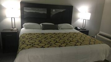 Een hotelkamer met een bed, twee nachtkastjes, een lamp, een telefoon en een verwarming.
