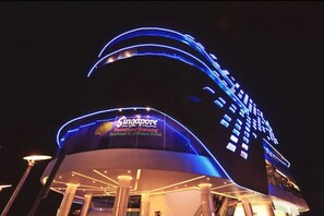 Un edificio moderno con fachada curva y señalización iluminada que dice "Singapore".