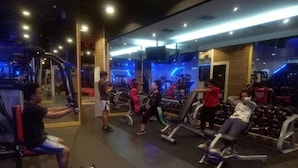 Ein Fitnessstudio mit verschiedenen Trainingsgeräten und Gewichten.