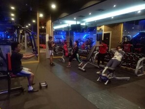 Ein Fitnessstudio mit verschiedenen Trainingsgeräten und Gewichten.