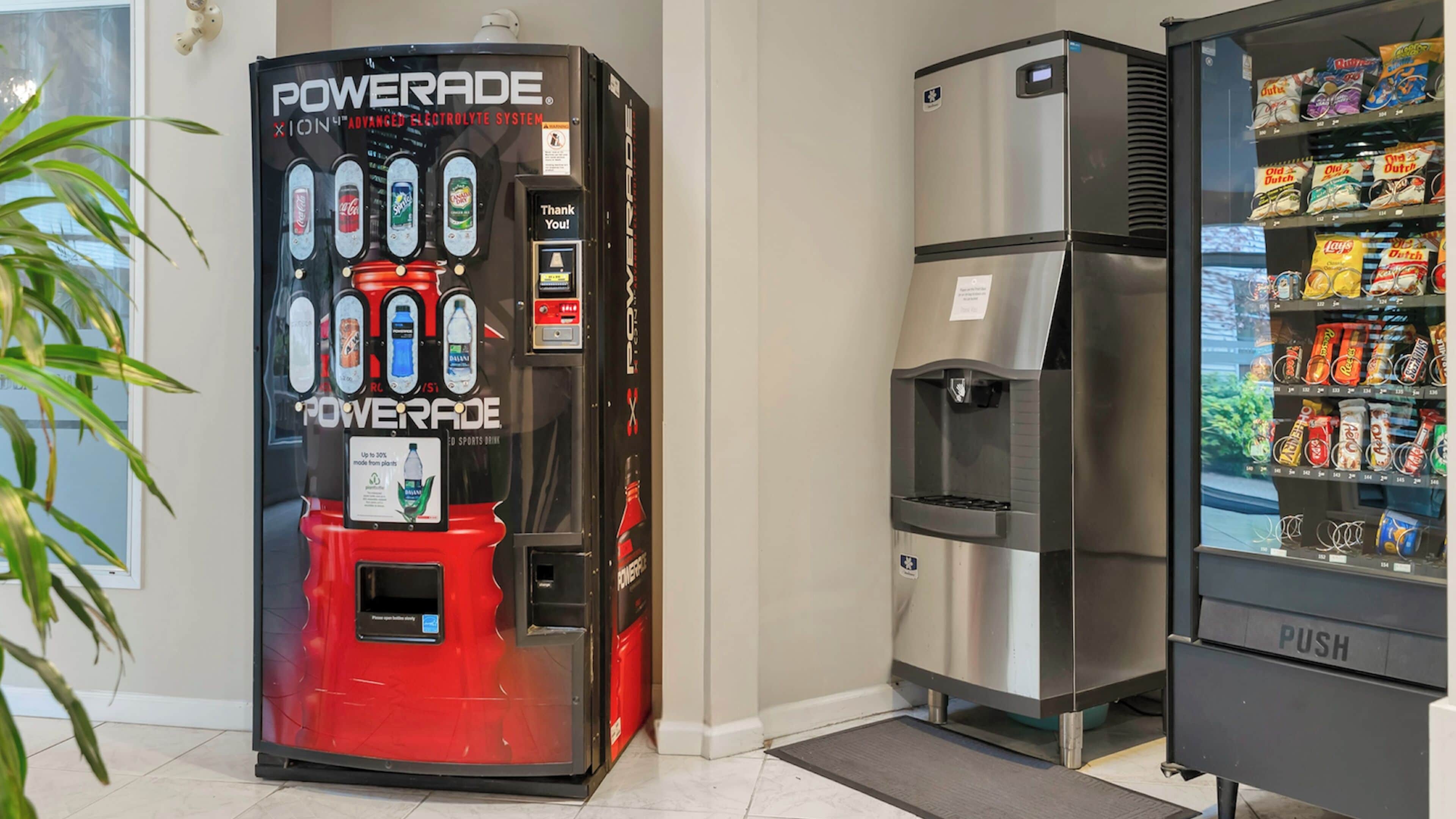 Máquina expendedora con dispensador de bebidas y refrigerador lleno de aperitivos.