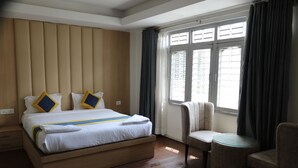 A hotel room with a large bed, a round table, and a chair. - Hotel Mustang Holiday Inn (Kathmandu)
