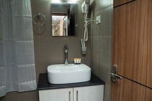 A bathroom with a white sink, a mirror, a hairdryer, and a towel ring. - Hotel Mustang Holiday Inn (Kathmandu)