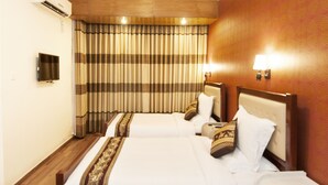 A hotel room with two beds, a television, and a wall-mounted air conditioner. - Century Park Residence (Dhaka)