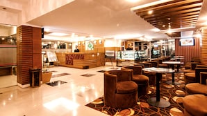 A lobby with a reception desk, seating area, and a glass display case. - Century Park Residence (Dhaka)