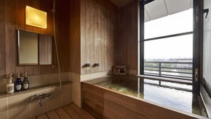 Un baño de madera con un ventanal grande, un espejo y una ducha.