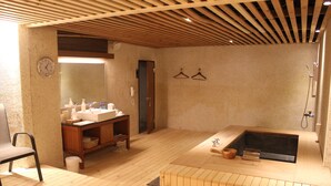 A wooden-floored bathroom with a wooden bench, a sink, and a bathtub. - Hoya Hot Springs Resort & Spa (Taimali)