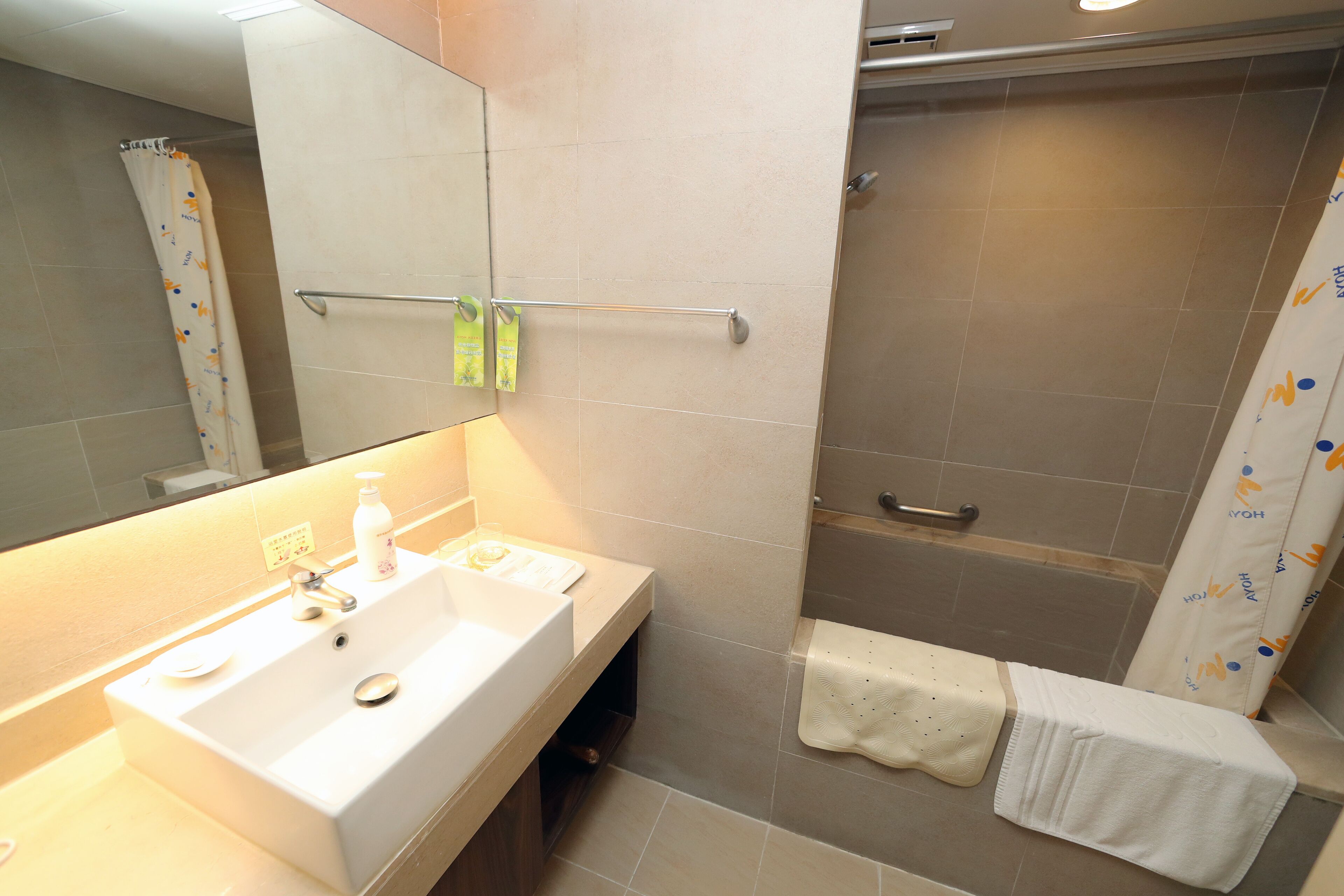 A bathroom with a sink, mirror, towel rack, and shower area.