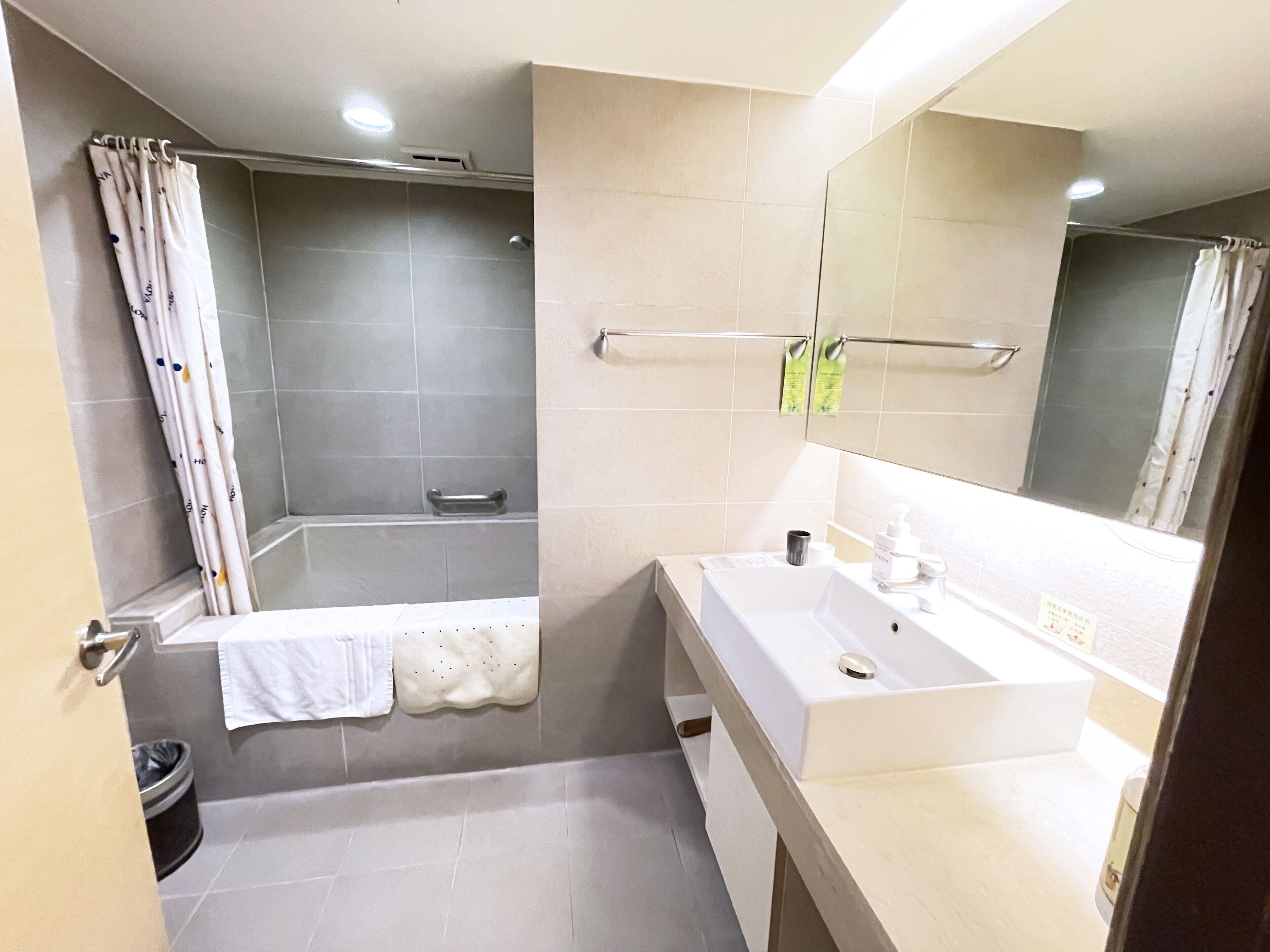 Un baño moderno con bañera, lavamanos y espejo.