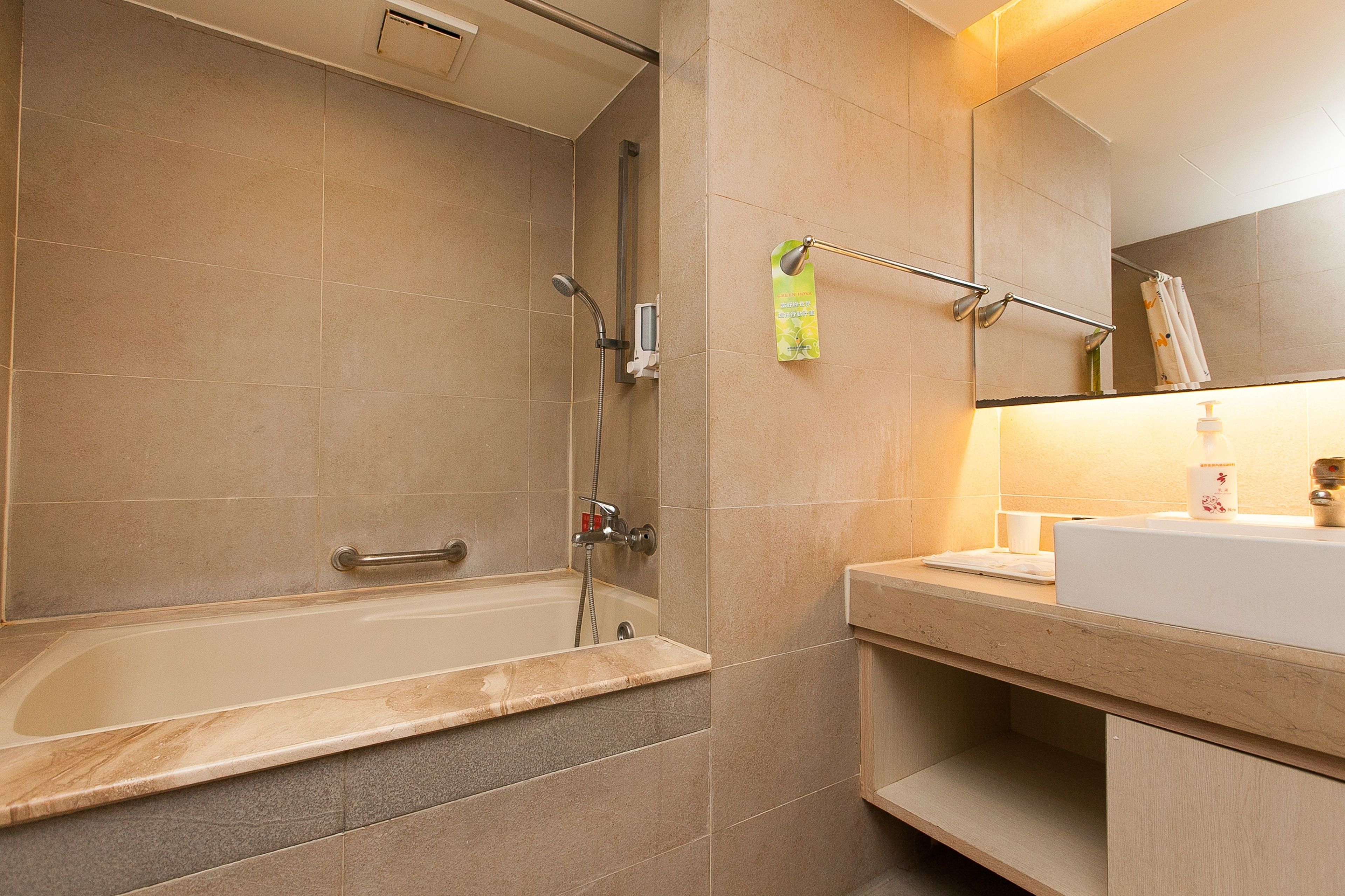 A modern bathroom with a bathtub, a shower, and a sink.
