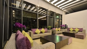 A modern lounge area with sofas and armchairs, large windows, and a ceiling with linear lighting. - Hoya Resort Hotel Taitung (Taitung)