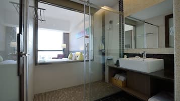 A modern bathroom with a glass shower enclosure, a white sink, and a large mirror.