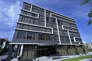 A modern multi-story hotel with a dark facade and white accents.