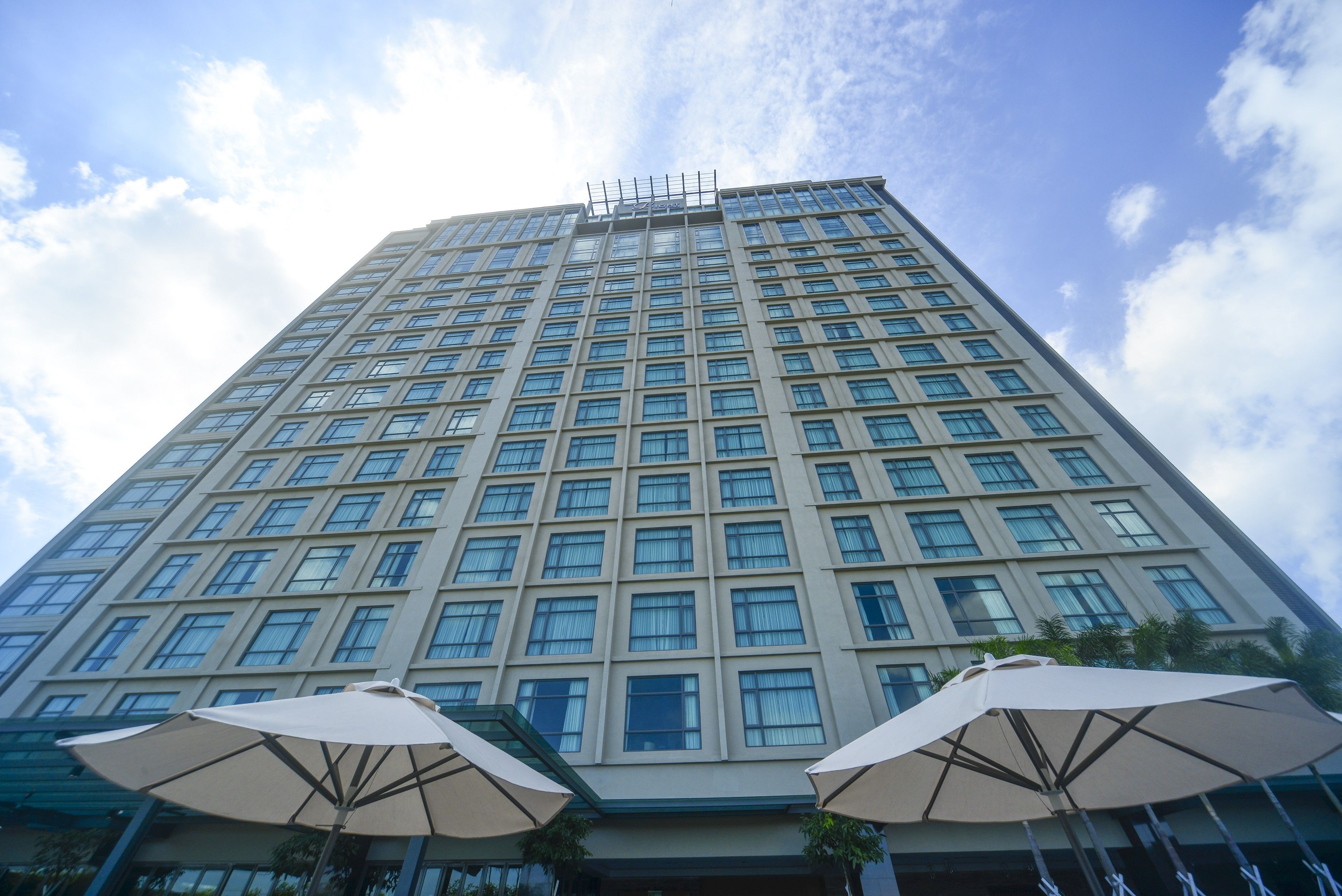 A tall hotel building with a grid of windows and a flat roof.