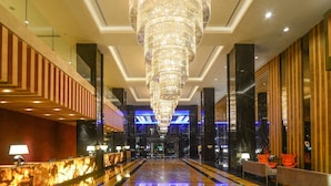 Eine geräumige Lobby mit einem großen Kronleuchter, Marmorböden und modernen Möbeln.