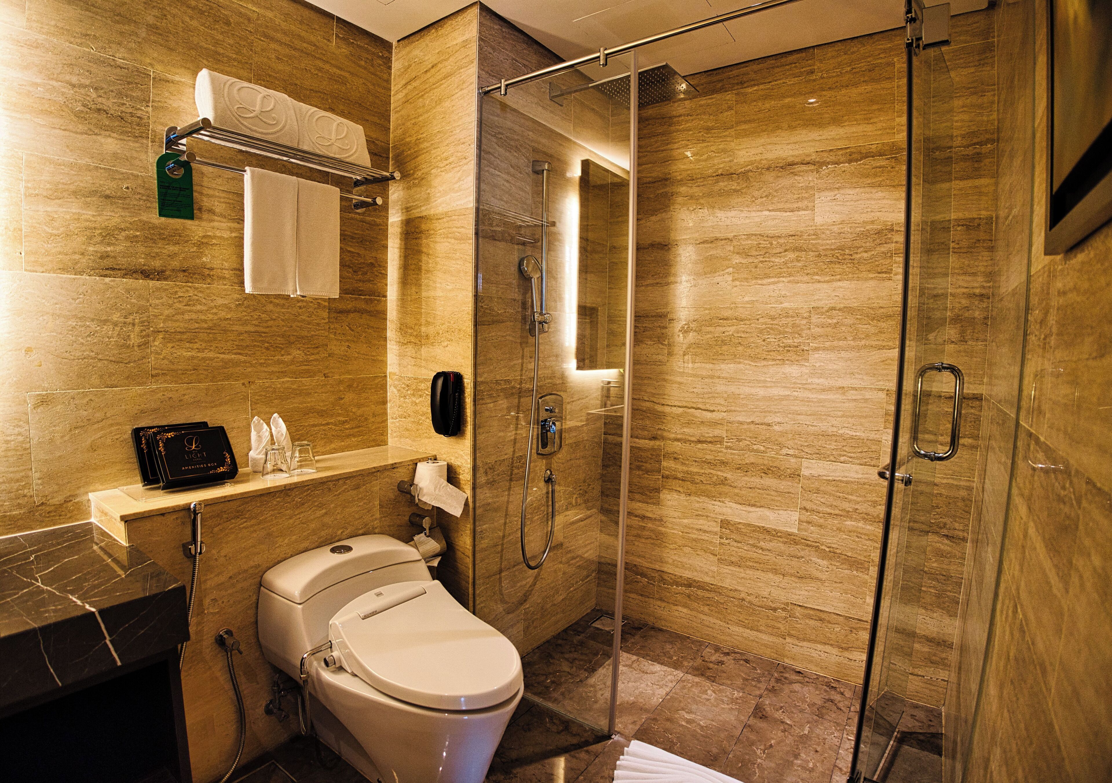 Une salle de bain moderne équipée de toilettes, d’un lavabo et d’une douche.