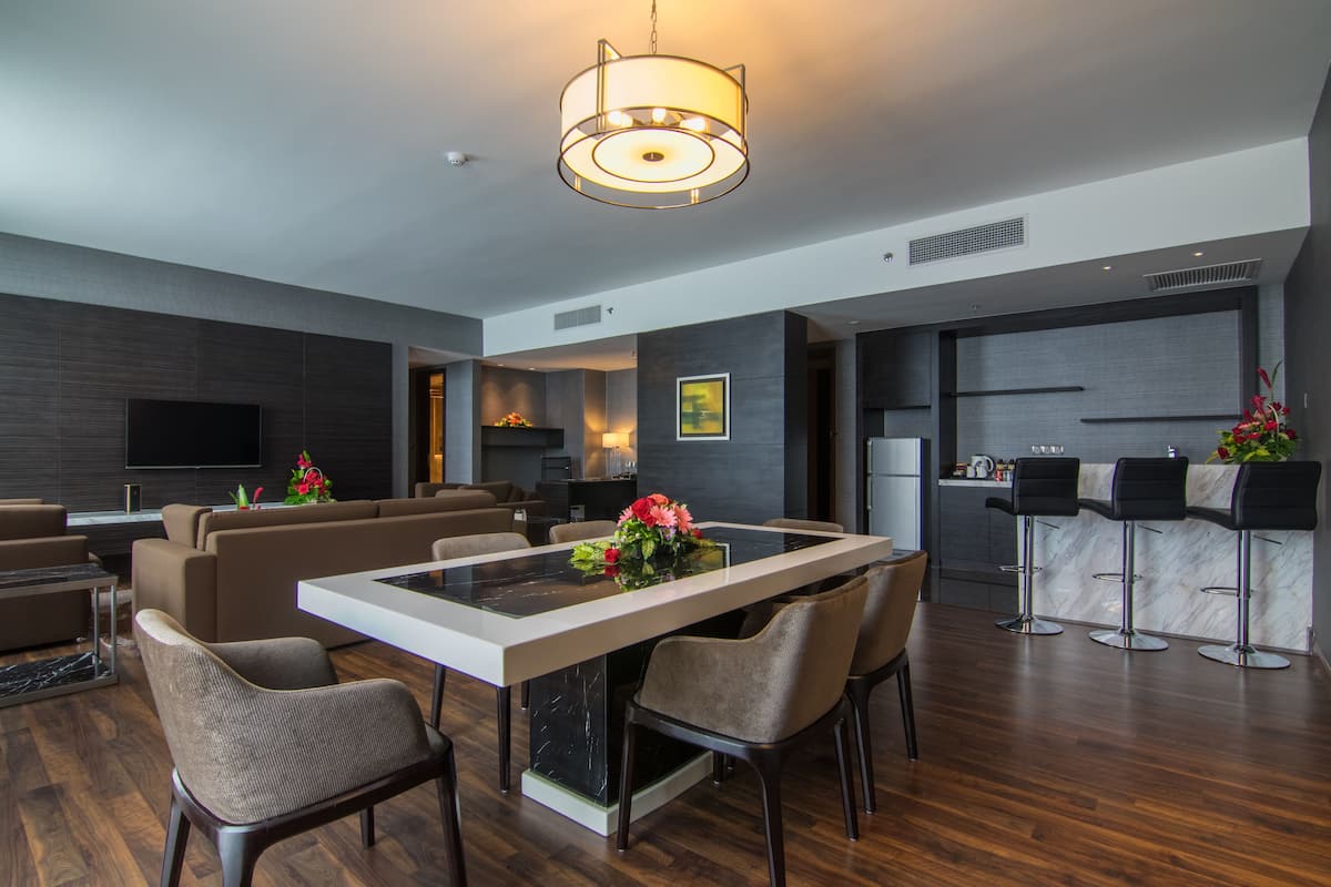 Une cuisine moderne avec des meubles de couleur sombre, un îlot central et un coin bar équipé de tabourets.