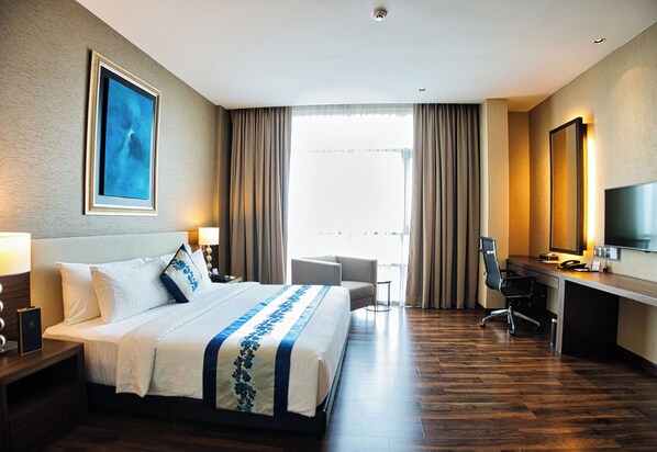 A hotel room with a large bed, a desk, a chair, a TV, and a window with curtains. - The Light Hotel Penang (Seberang Jaya)