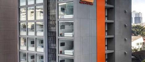 A modern building with a prominent 'SBOX' sign, featuring a grid of rooms with visible storage units.