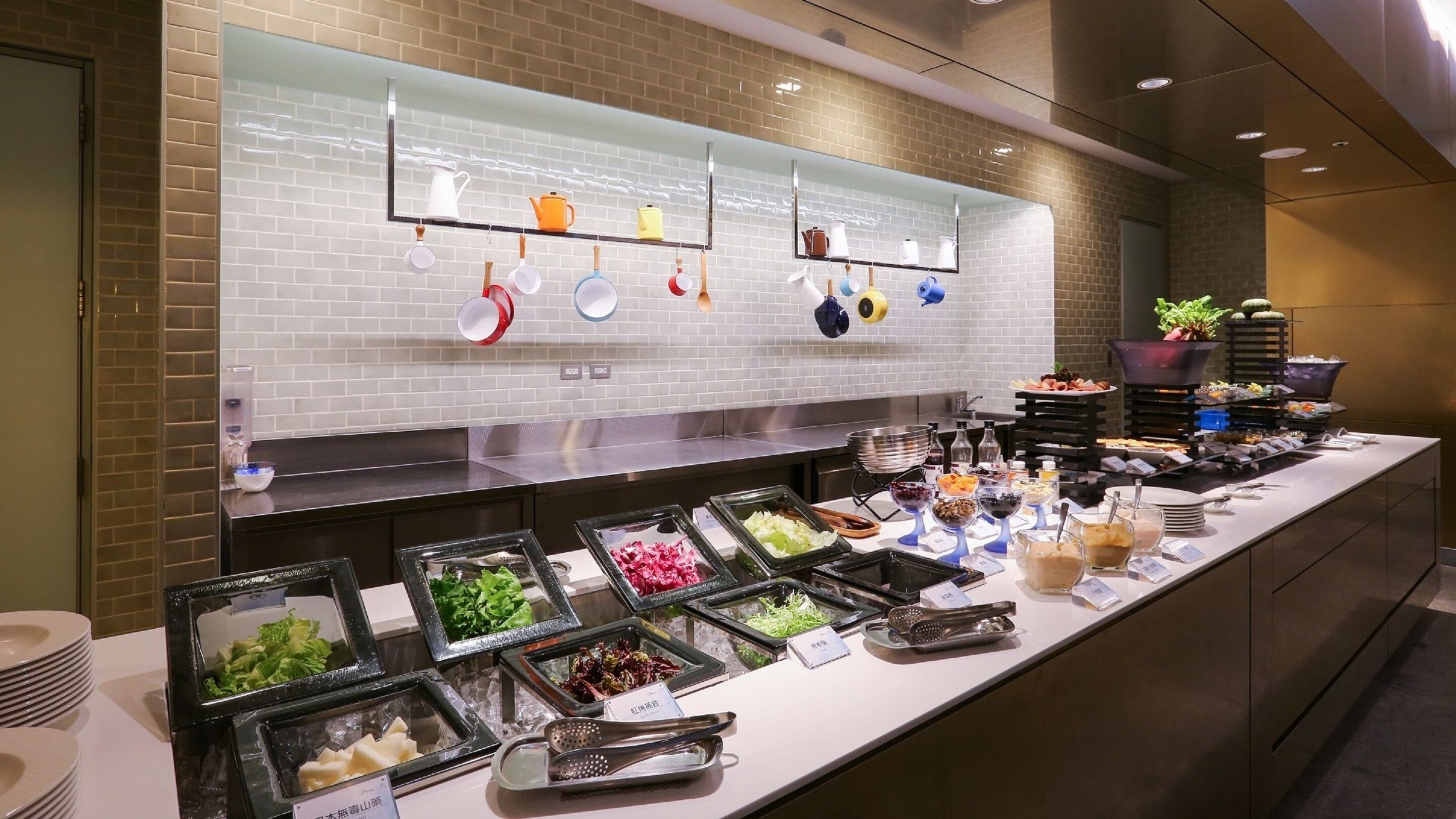 A buffet setup with various food items and utensils.