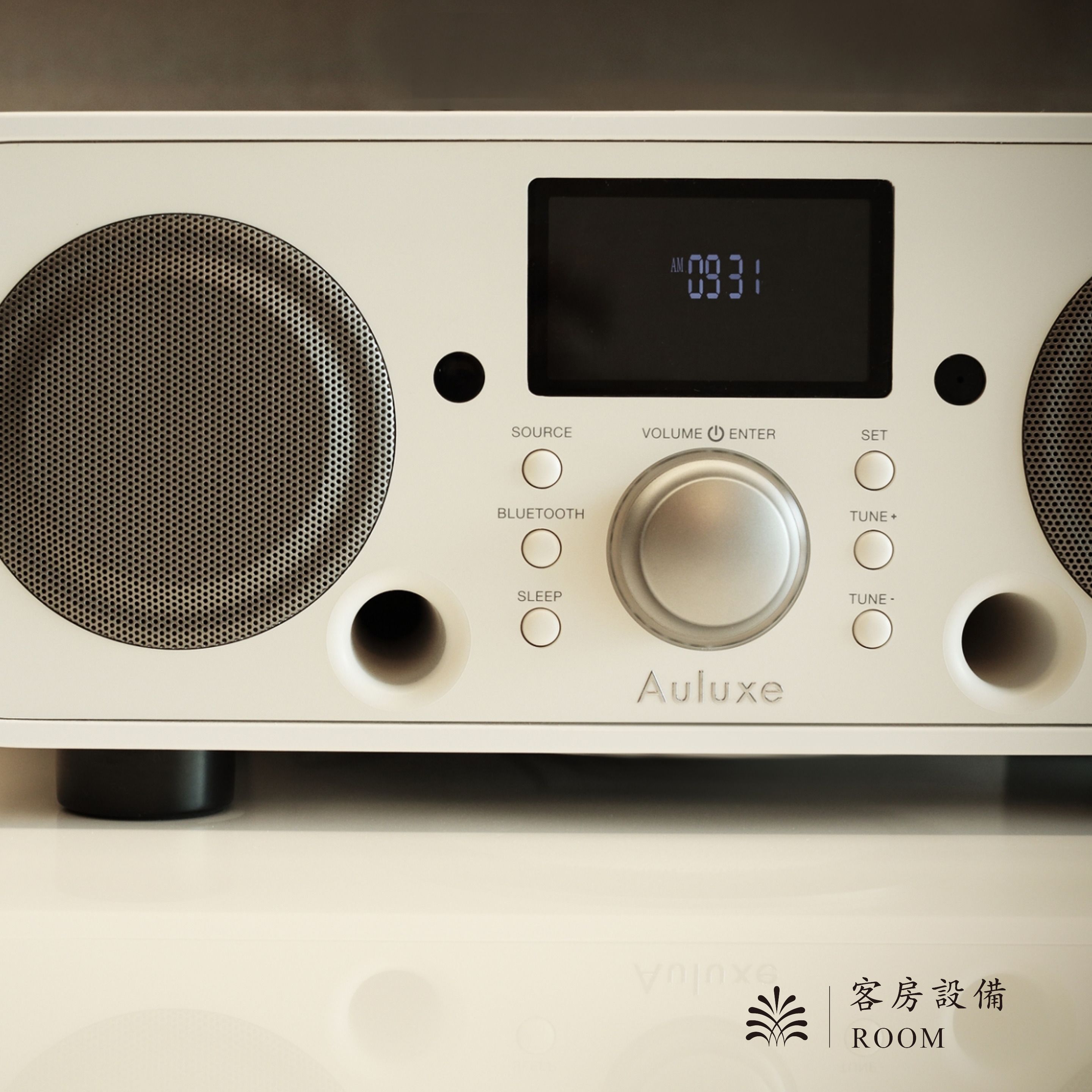 A white audio device with a digital display, volume control, and multiple connectivity options.