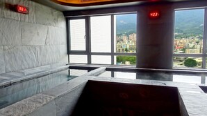 A modern interior with a large window, a digital thermometer, and a view of a cityscape. - Hotel Royal Beitou (Taipei)