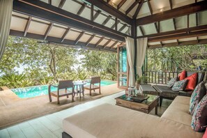 A spacious outdoor seating area with a pool, wooden furniture, and a view of lush greenery. - Koh Jum Beach Villas “A member of Secret Retreats” (Nuea Khlong)