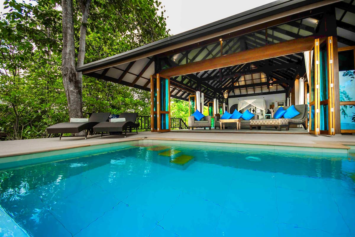 Un espace aménagé au bord de la piscine, avec des chaises longues et un coin salon abrité.