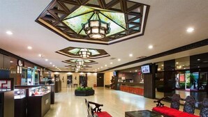 Un lobby amplio con mostrador de recepción, área de descanso y un techo decorativo.