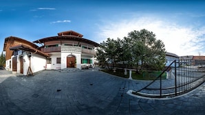 A multi-story building with a curved roof, a paved courtyard, and a small water feature. - Vitusfort (Fuessen)
