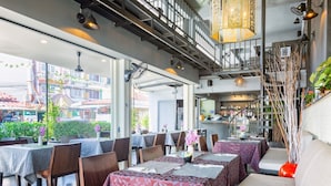 Un restaurant avec plusieurs tables, un escalier et une vue sur la rue.