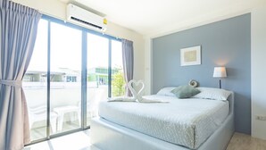 Une chambre à coucher avec un lit, une fenêtre avec des rideaux, un climatiseur fixé au mur et une lampe de chevet.
