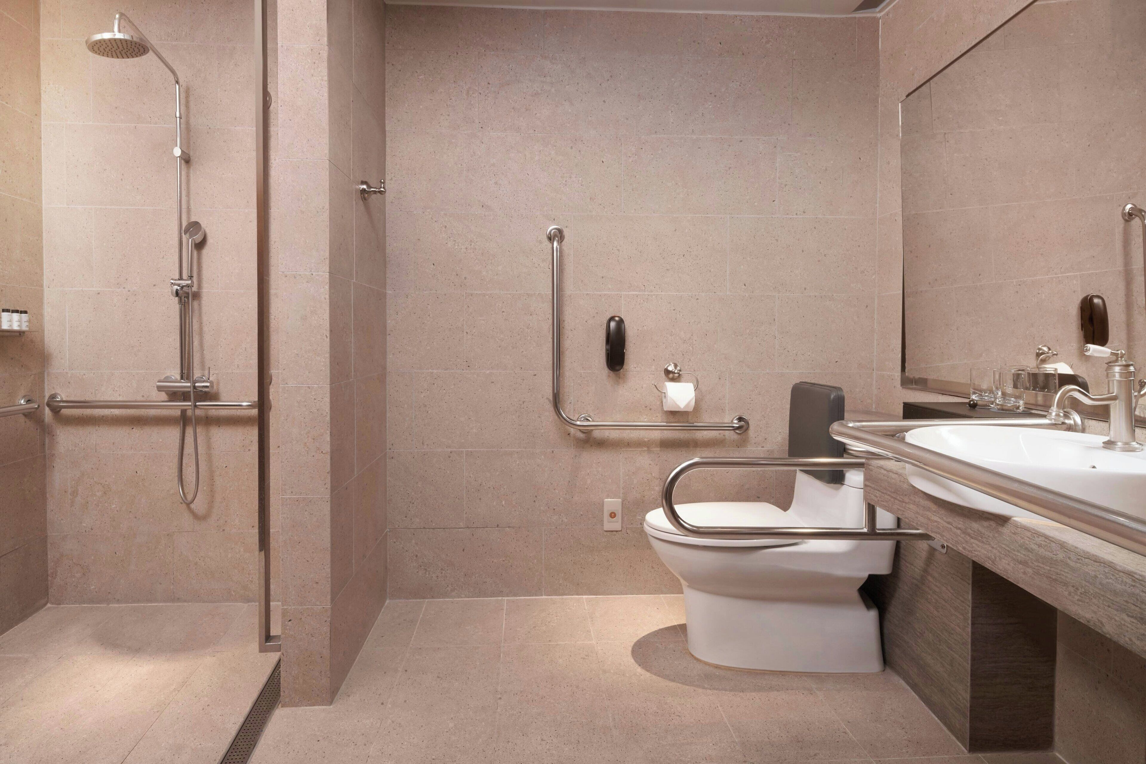 A modern bathroom with a shower, toilet, and sink.