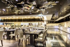 A modern restaurant with a long counter and multiple tables. - Sheraton Taitung Hotel (Taitung)