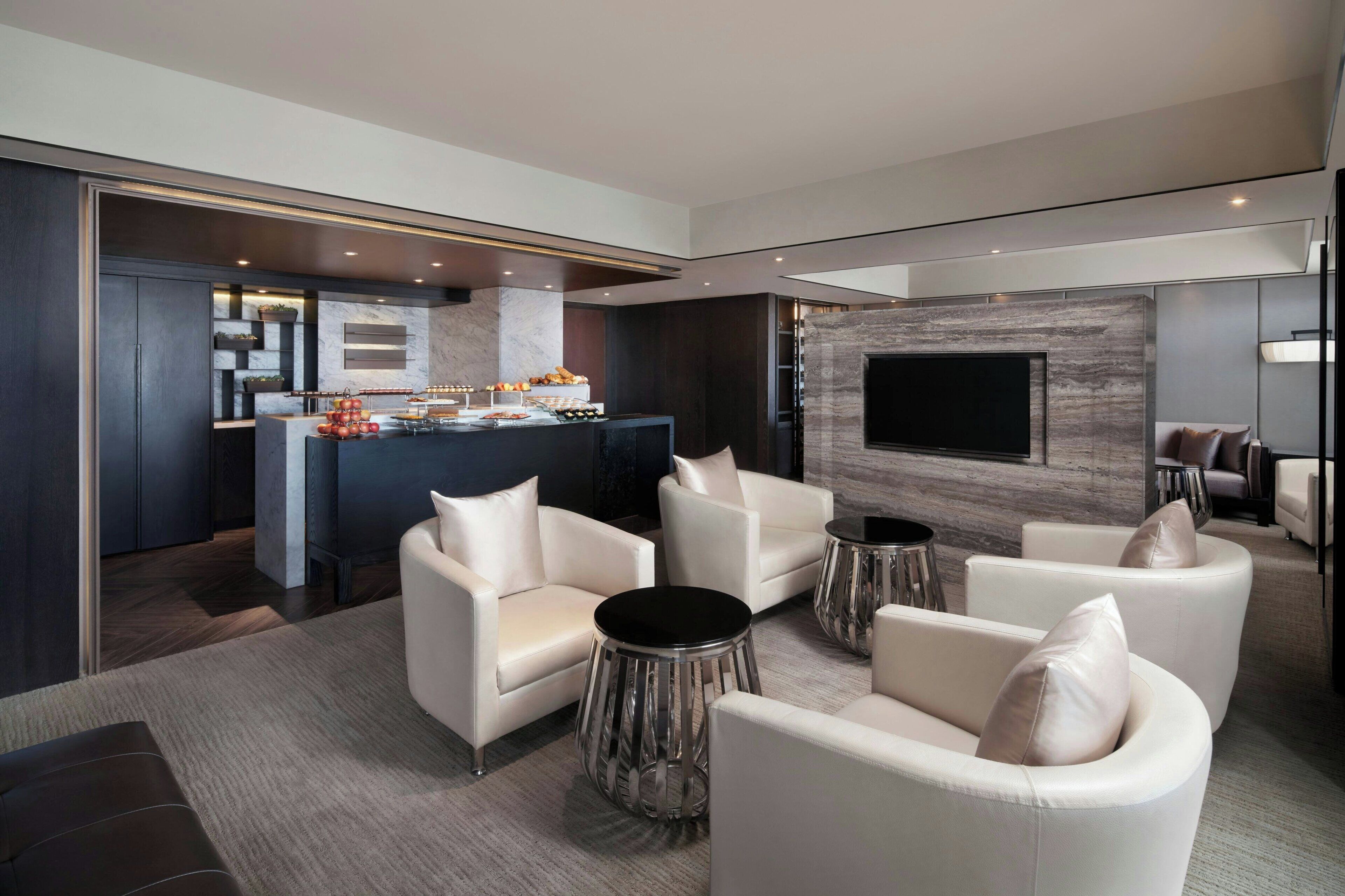 A modern living room with a sofa set, a coffee table, and a TV mounted on the wall.