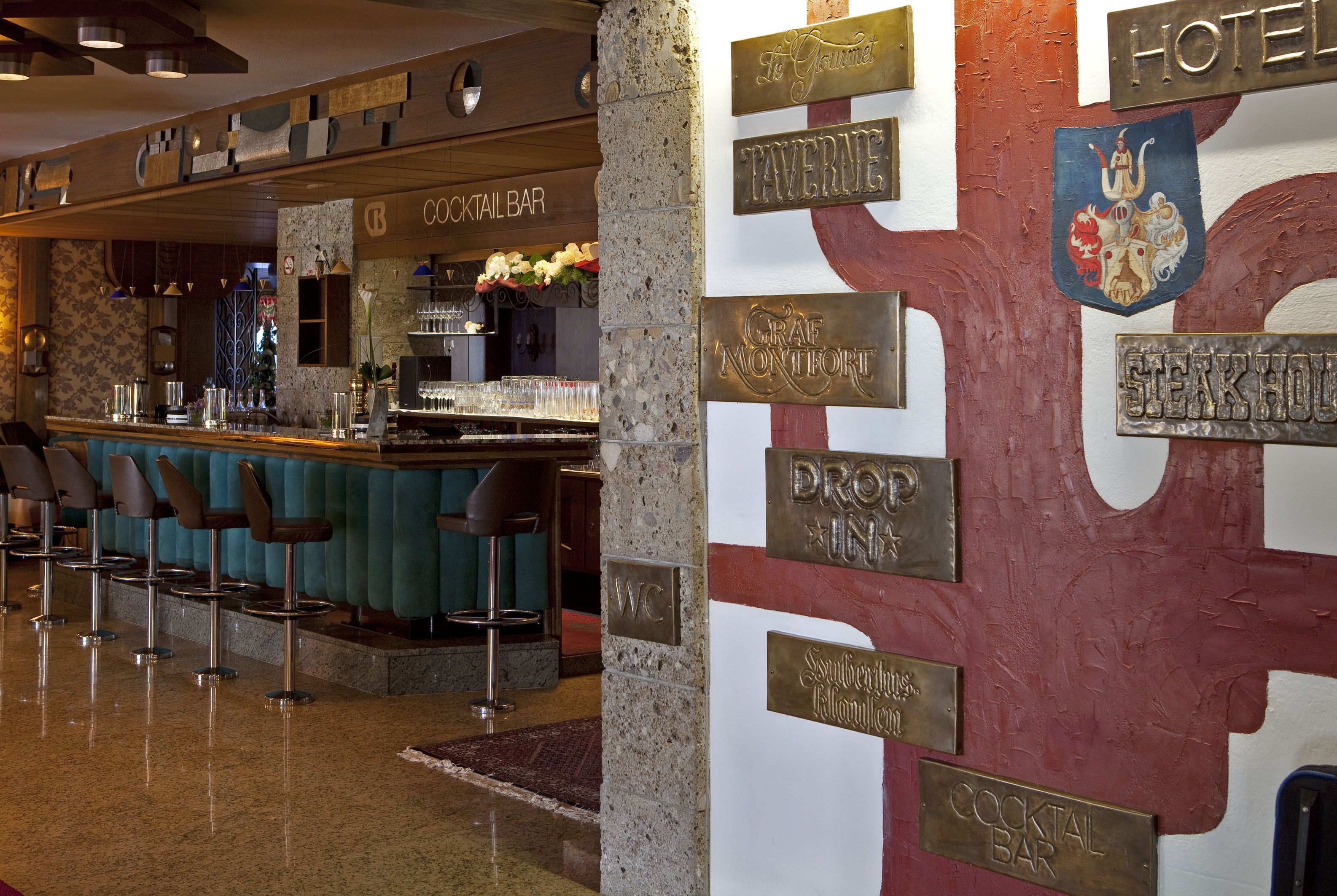 A bar area with a counter, stools, and a sign indicating a cocktail bar.