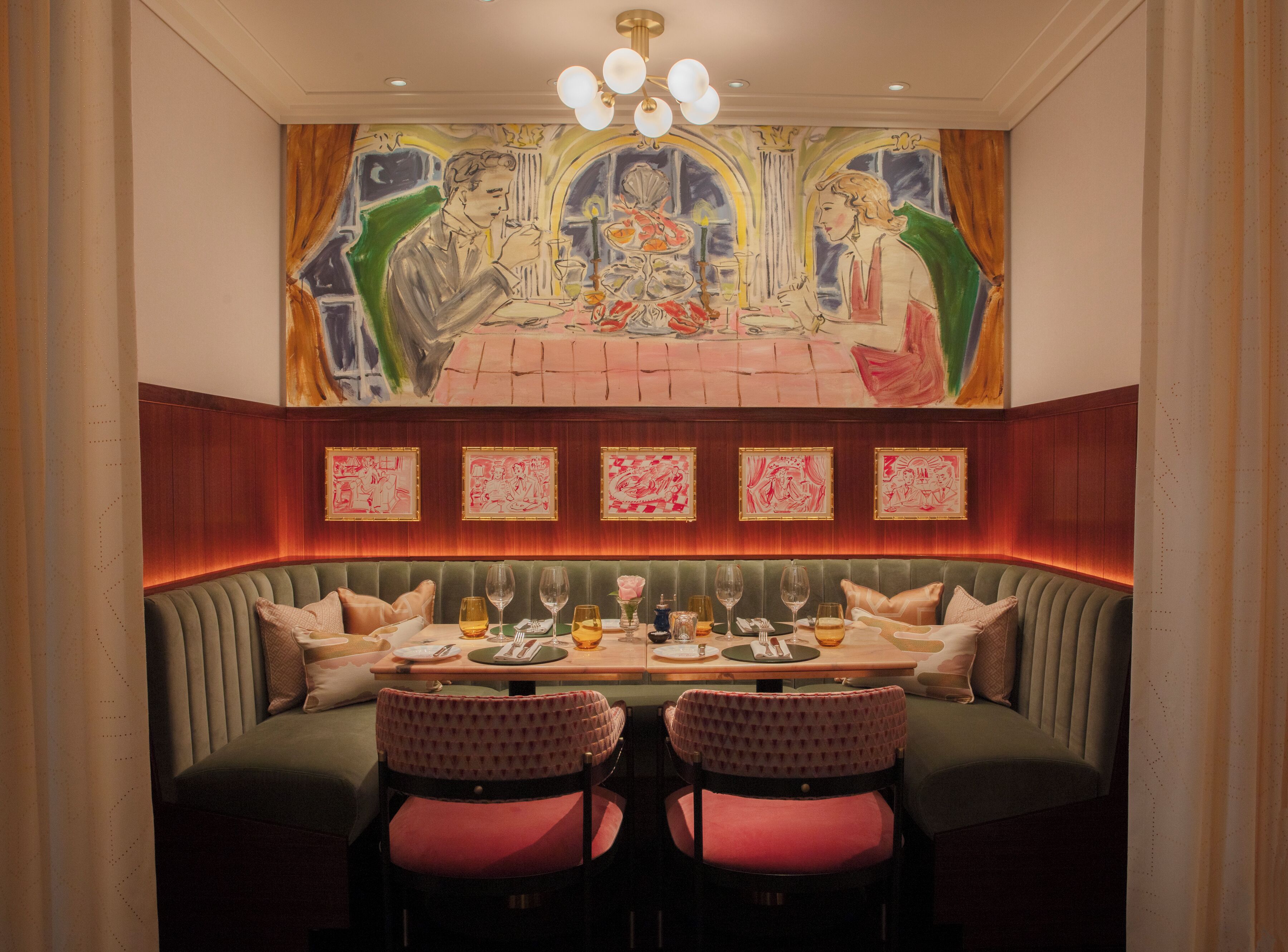 A dining area with a high-backed booth seating, a table set with glasses and cutlery, and a mural above the seating.