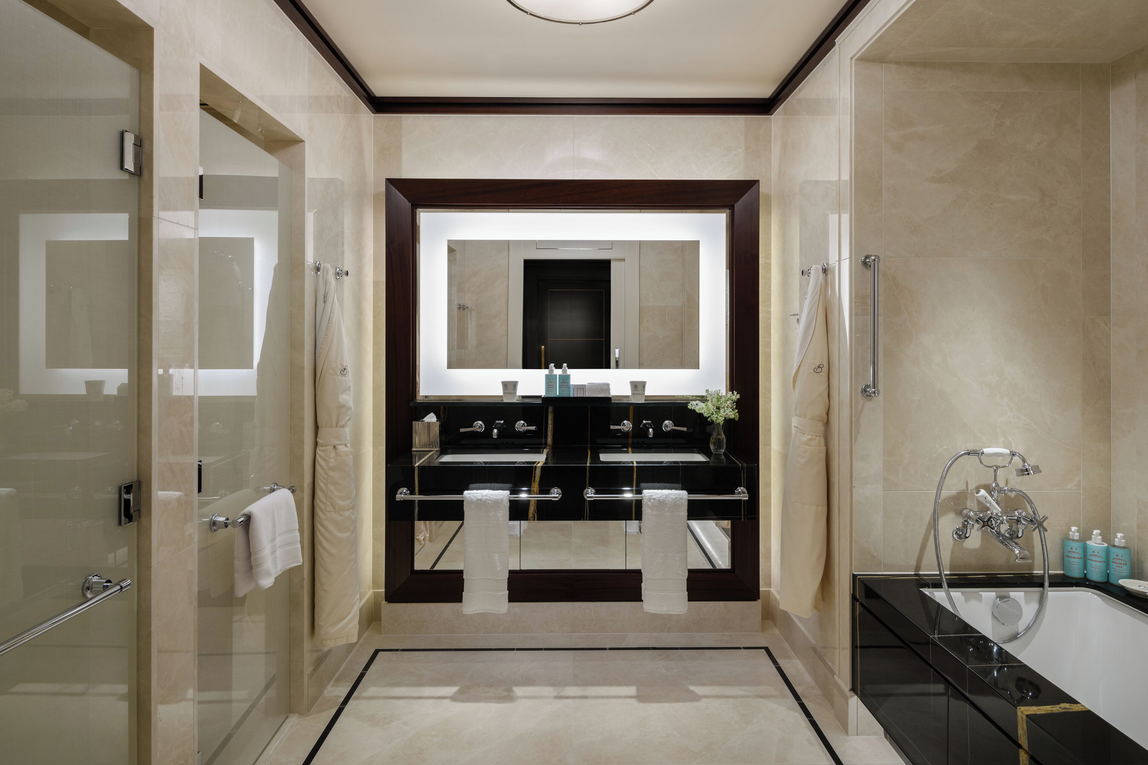 A modern bathroom with a double sink vanity, a glass shower enclosure, and a separate bathtub.