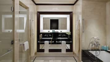 A modern bathroom with a double sink vanity, a glass shower enclosure, and a separate bathtub.